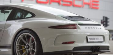 Une Porsche 911 devant le logo de la marque