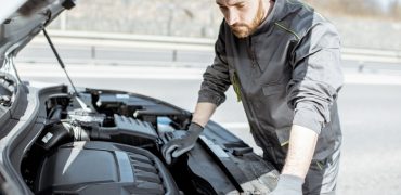 Personne réparant une voiture avec des pièces d'occasion